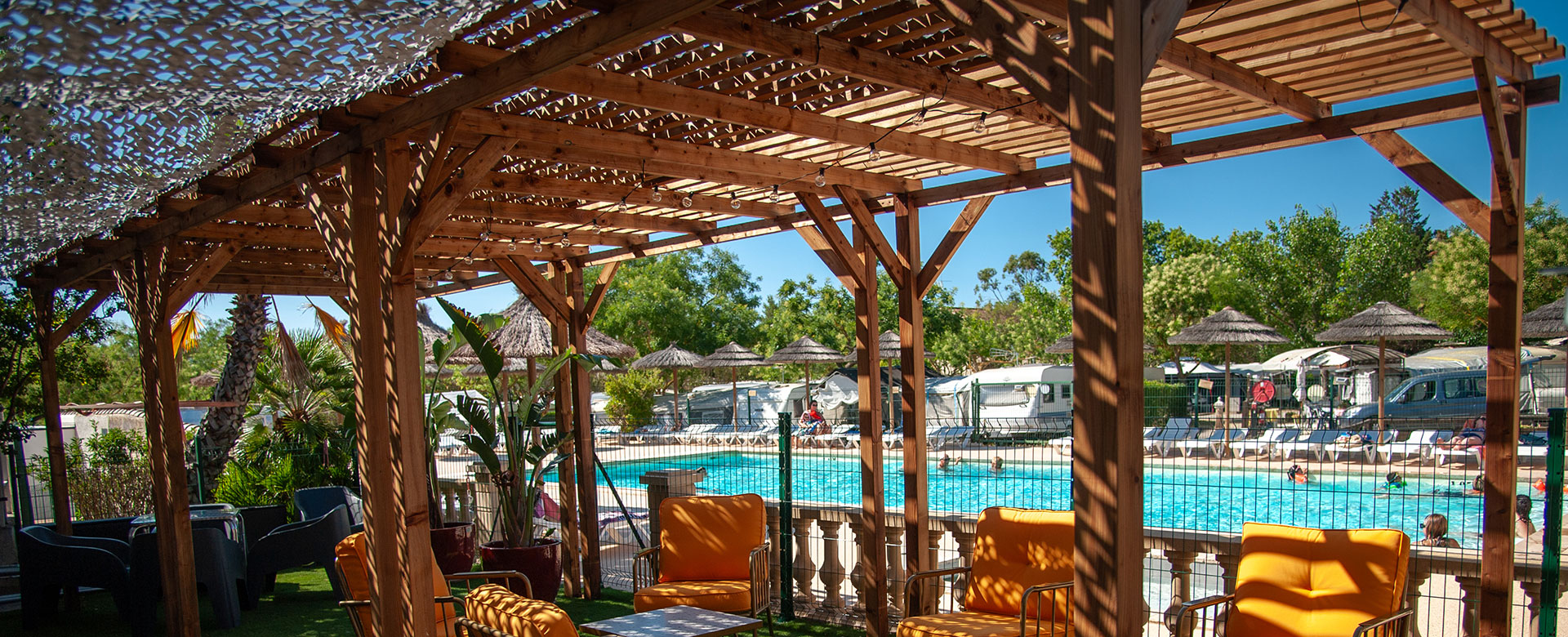 The swimming pool at La Gabinelle campsite in Sauvian in the Hérault region with a shaded terrace