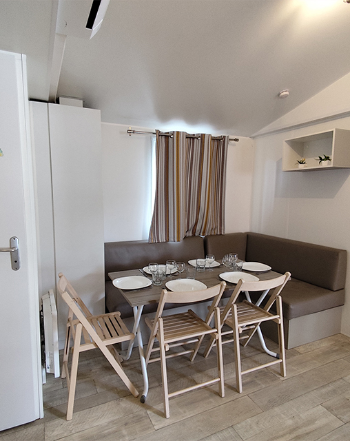 Die Sitzecke der Mobilheime mit 2 Zimmern für 5 Personen, zu vermieten auf dem Campingplatz La Gabinelle in der Nähe von Sérignan im Hérault
